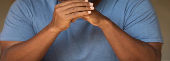 man listening with clasped hands