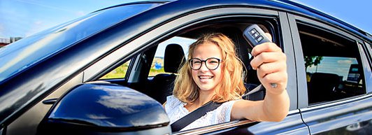 Teen Girl in the driver's seat showing off the car keys