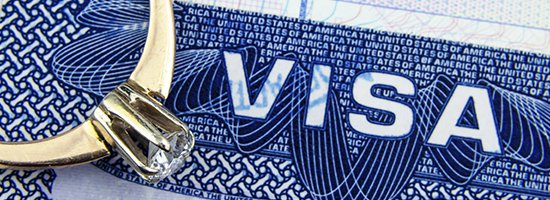 An engagement ring rests on a visa document