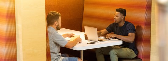 2 people meeting in a booth