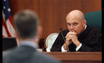 judge staring at person in suit