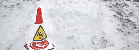 Cone in snow with slip sign