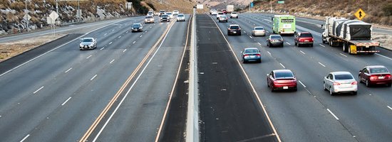 looking down a highway with more cars driving away