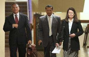 Attorney William Harrison walking with 2 other people
