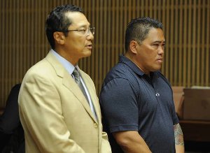Attorney William Harrison speaking in a courtroom with a client by his side