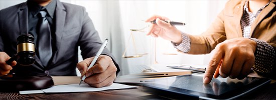 Person Pointing to iPad next to Person Writing